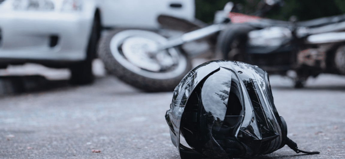 A helmet laying next to a motorcycle crash